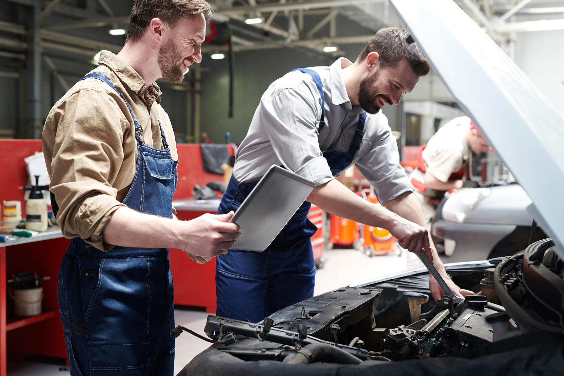Automotive technicians inspecting a vehicle together